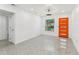 Bright living room with minimalist decor, a modern ceiling fan, and a colorful front door at 1868 Douglas Ave, Dunedin, FL 34698