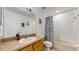 Bright bathroom features a single sink, large mirror, and a shower-tub combination with decorative curtain at 18822 Quarry Badger Rd, Land O Lakes, FL 34638