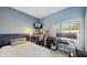 This bedroom features light blue walls, two work stations, carpeted floor and a window to allow for light at 18822 Quarry Badger Rd, Land O Lakes, FL 34638