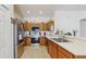 Well-lit kitchen featuring stainless steel appliances, ample countertop space, tile floors and wooden cabinetry at 18822 Quarry Badger Rd, Land O Lakes, FL 34638