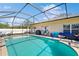 Relaxing screened-in pool area with patio furniture, grill, and access to the house and a lush lawn at 18822 Quarry Badger Rd, Land O Lakes, FL 34638