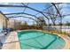 Sparkling screened-in pool with brick paver deck, surrounded by well-maintained landscaping at 18822 Quarry Badger Rd, Land O Lakes, FL 34638