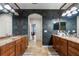 Bathroom with double vanity, decorative mirrors, granite countertops, and floral wallpaper at 19238 Climbing Aster Dr, Tampa, FL 33647