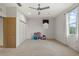 Large bedroom with ceiling fan, neutral carpet, and natural light from the window at 19238 Climbing Aster Dr, Tampa, FL 33647