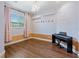 Bedroom features hardwood flooring, large window, hanging chandelier, and keyboard at 19238 Climbing Aster Dr, Tampa, FL 33647