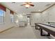 Bright game room with shuffleboard table, natural light, and neutral carpeting at 19238 Climbing Aster Dr, Tampa, FL 33647