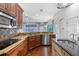 Gourmet kitchen featuring wood cabinets, granite countertops, stainless steel appliances, and an eat-in island at 19238 Climbing Aster Dr, Tampa, FL 33647