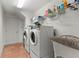Functional laundry room with washer, dryer, sink, and shelving at 19238 Climbing Aster Dr, Tampa, FL 33647