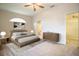 Bright bedroom featuring carpeted floors, a ceiling fan, ensuite bathroom and a large walk-in closet at 2166 Andrews Ct, Dunedin, FL 34698