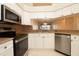 Contemporary kitchen with stainless steel appliances, granite countertops, and a convenient pass-through to the dining room at 2166 Andrews Ct, Dunedin, FL 34698