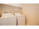 Bright laundry room with a washer, dryer, storage cabinets, and overhead rack at 2166 Andrews Ct, Dunedin, FL 34698