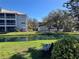 This condo building features a serene pond view with fountain, surrounded by lush greenery and mature trees at 2210 Vista Del Sol Cir # 519, Lutz, FL 33558