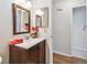 Bathroom with vanity, wooden mirror, and wood-look flooring leading to another room at 2301 Grenoble Pl # 1, Sun City Center, FL 33573
