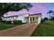 Charming single-story home featuring a covered carport, white exterior, and manicured landscaping at 2301 Grenoble Pl # 1, Sun City Center, FL 33573