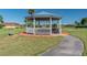 Charming gazebo with a blue roof and white columns, offering a relaxing space in a landscaped community area at 2301 Grenoble Pl # 1, Sun City Center, FL 33573