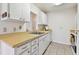 Bright kitchen features white cabinets and neutral countertops, offering a clean and functional space for cooking at 2301 Grenoble Pl # 1, Sun City Center, FL 33573