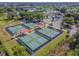 Aerial view of multiple outdoor pickleball courts at a community center featuring covered seating areas and parking at 2301 Grenoble Pl # 1, Sun City Center, FL 33573