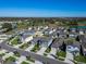 Aerial view showcases a community with mature trees, ponds, and manicured lawns at 3204 Fresno Pl, Zephyrhills, FL 33541