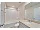 Bright bathroom featuring a shower over tub and a vanity with granite countertop and large mirror at 3204 Fresno Pl, Zephyrhills, FL 33541