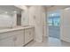 Well lit bathroom featuring double vanity, shower, and bedroom view at 3204 Fresno Pl, Zephyrhills, FL 33541