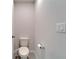 A well-lit bathroom features a toilet, paper holder, and light switches at 3204 Fresno Pl, Zephyrhills, FL 33541