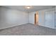 A simple bedroom with neutral carpeting and a door to the bathroom at 3204 Fresno Pl, Zephyrhills, FL 33541
