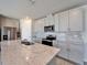 Close-up of the kitchen island featuring granite counters, stainless steel sink, modern faucet, and gray cabinets at 3204 Fresno Pl, Zephyrhills, FL 33541
