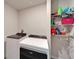 Laundry room with full-size washer and dryer and organized shelving for storage at 3204 Fresno Pl, Zephyrhills, FL 33541