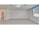Bright living room featuring neutral walls, wood-look tile flooring and a large window for ample natural light at 3204 Fresno Pl, Zephyrhills, FL 33541