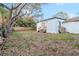 Expansive backyard featuring mature trees and the exterior of a charming light blue house at 3307 S Manhattan Ave, Tampa, FL 33629