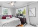 Bright bedroom with a large window, comfortable bed, ceiling fan, and neutral decor at 3307 S Manhattan Ave, Tampa, FL 33629