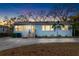Charming one-story home with blue siding, a paved driveway, and mature trees, perfect for peaceful living at 3307 S Manhattan Ave, Tampa, FL 33629