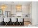 Bright kitchen has a large center island with seating, white cabinets, and elegant woven pendant lights at 3721 Iris N St, St Petersburg, FL 33704