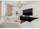 Bright living room featuring white couch, TV, and modern ceiling fixture at 3721 Iris N St, St Petersburg, FL 33704
