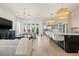 Open-concept living room featuring a kitchen island, hardwood flooring, and stylish light fixtures at 3721 Iris N St, St Petersburg, FL 33704