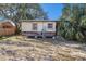 Exterior view of a distressed bungalow with weathered facade and overgrown yard at 4029 13Th S Ave, St Petersburg, FL 33711