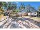 View of a large, open yard with scattered trees and a wooden fence in the background at 4029 13Th S Ave, St Petersburg, FL 33711