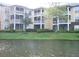 Multi-story condo building overlooking a pond, screened patios and lush landscaping at 4211 Chatham Oak Ct # 122, Tampa, FL 33624