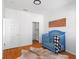 Well-lit Bedroom features a charming blue crib, wood floors, and an organized walk-in closet at 4339 Spinnaker Cove Ln, Tampa, FL 33615