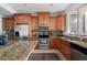 Well-lit kitchen featuring stainless steel appliances, granite countertops, and warm wood cabinetry at 4339 Spinnaker Cove Ln, Tampa, FL 33615