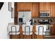 Close up of a modern kitchen bar with seating, stainless appliances, and wooden cabinetry at 4339 Spinnaker Cove Ln, Tampa, FL 33615
