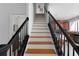 Staircase with black railings and wood treads leads to the upper level, adjacent to the kitchen at 4339 Spinnaker Cove Ln, Tampa, FL 33615