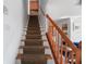 Carpeted staircase featuring wood railings and trim, leading to upper level with landing and bathroom view at 4339 Spinnaker Cove Ln, Tampa, FL 33615