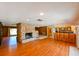 Spacious living room featuring hardwood floors and a stone fireplace open to the kitchen with bar seating at 555 Hickory St, Brooksville, FL 34601