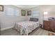 Bedroom showcasing a patterned quilt bed, two sunny windows, and neutral wall color at 608 Florida S Cir, Apollo Beach, FL 33572