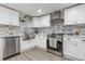 Updated kitchen with stainless steel appliances, granite countertops, and white cabinets at 608 Florida S Cir, Apollo Beach, FL 33572