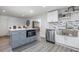 Kitchen features a gray island with microwave and seating, modern appliances, and wood-look floors at 608 Florida S Cir, Apollo Beach, FL 33572