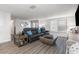 Bright living room features a comfortable gray sofa, stylish accents, and wood-look flooring at 608 Florida S Cir, Apollo Beach, FL 33572