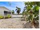 Secluded backyard featuring white vinyl fence, tropical foliage, and low-maintenance gravel at 652 Ohio Pl, Sarasota, FL 34236