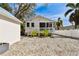 Charming home with a quaint screened-in porch, white fence, and tropical landscaping at 652 Ohio Pl, Sarasota, FL 34236